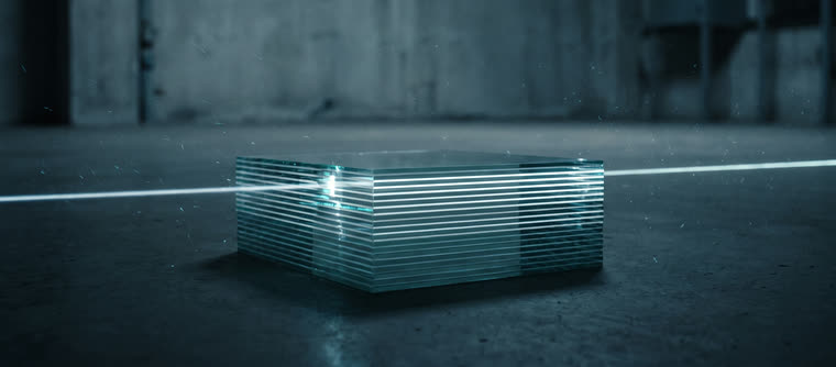 Un trait de lumière balaie une pile de plaques de verre parfaitement alignées.
